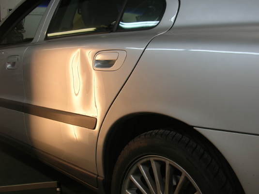 Volvo door with large dent before paintless repair